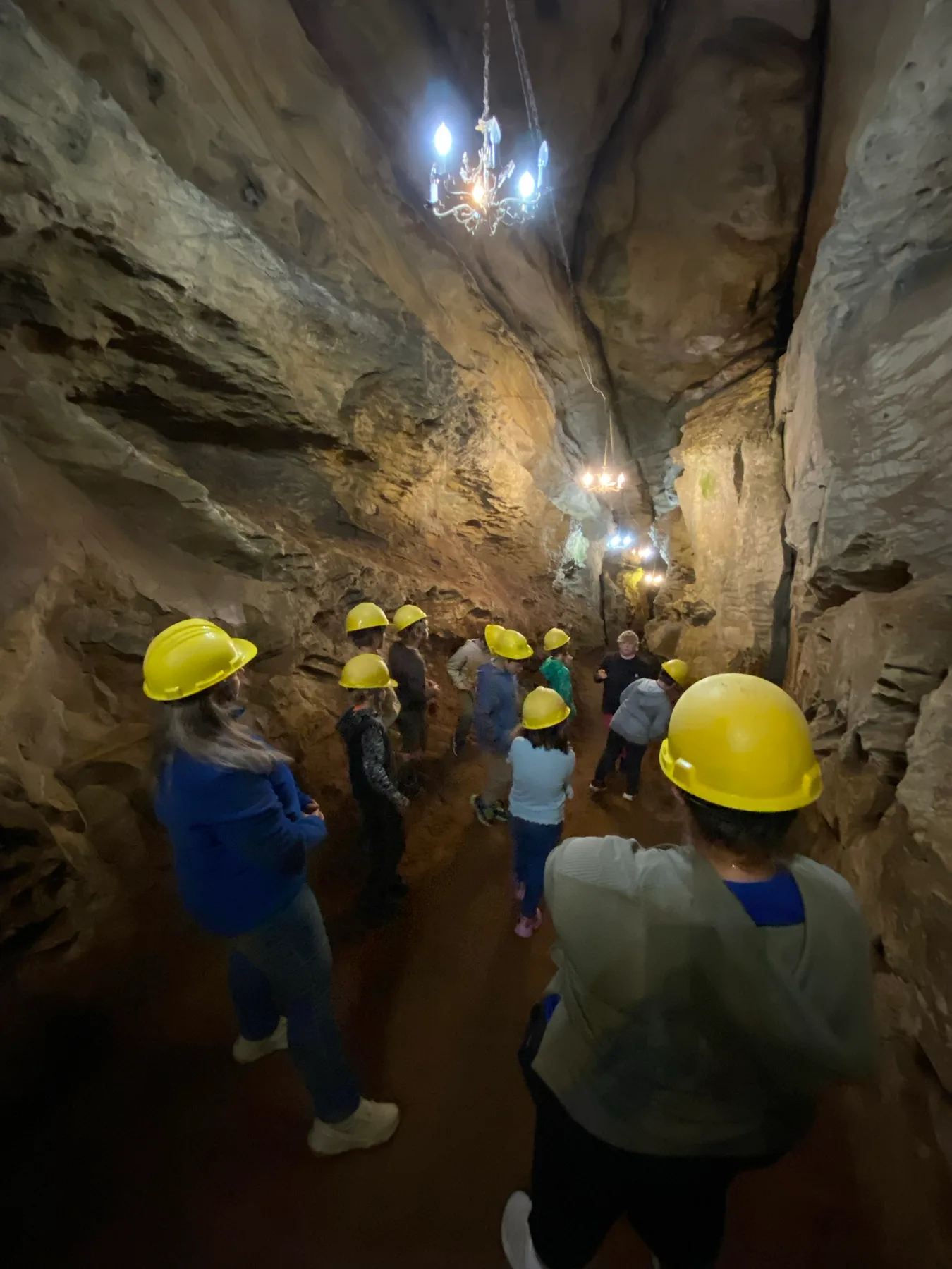 Scouts gathered beneath tall rock walls inside Laurel Caverns