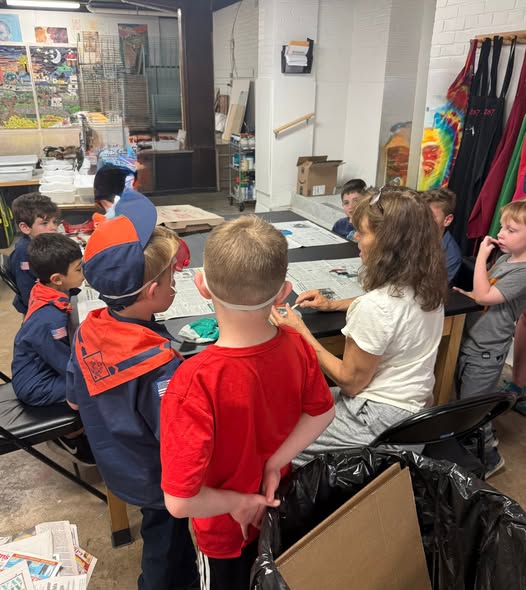 Scouts gathered around a table during a mosaic art workshop