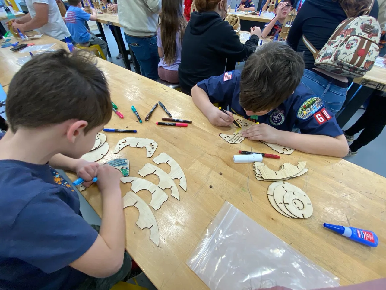 Scouts decorating and assembling wooden engineering projects at STEM Day at WVU