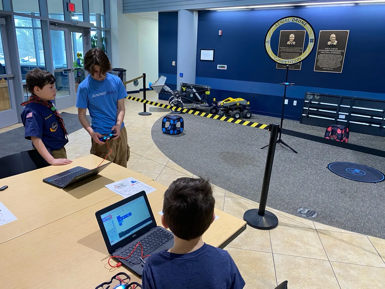 A scout learning to program and fly a small drone during STEM Day at WVU