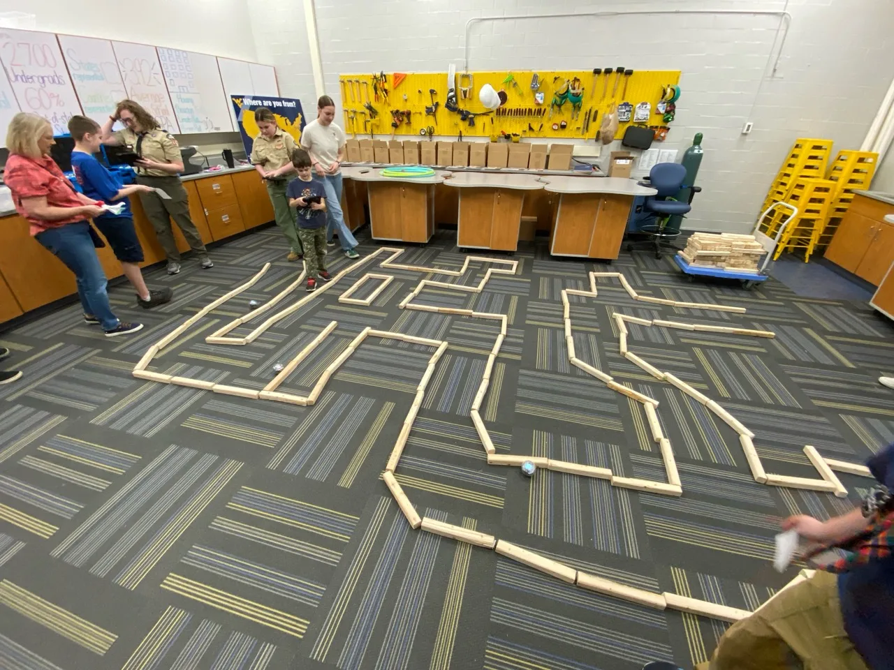 Scouts guiding small robots through a large maze during STEM Day at WVU